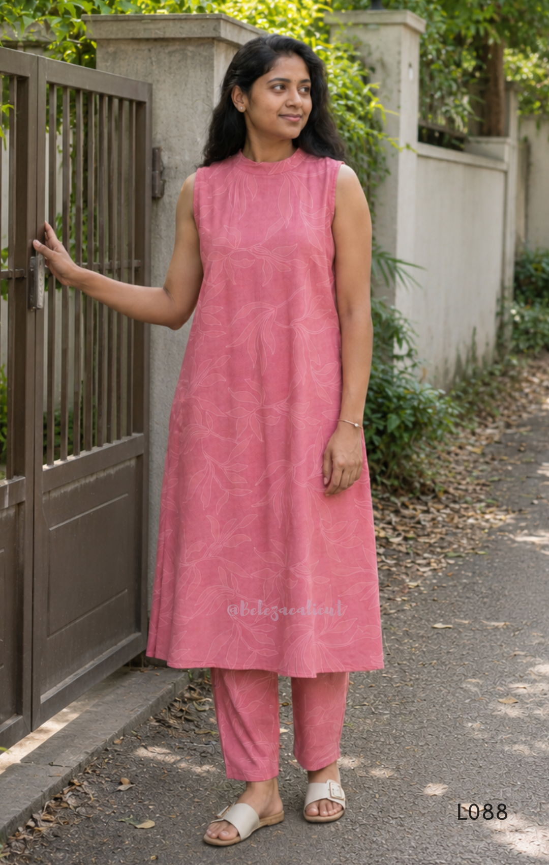 Coral pink rayon blend 2-piece set with white leaf line print, high neck top, back zip and matching printed straight pant.