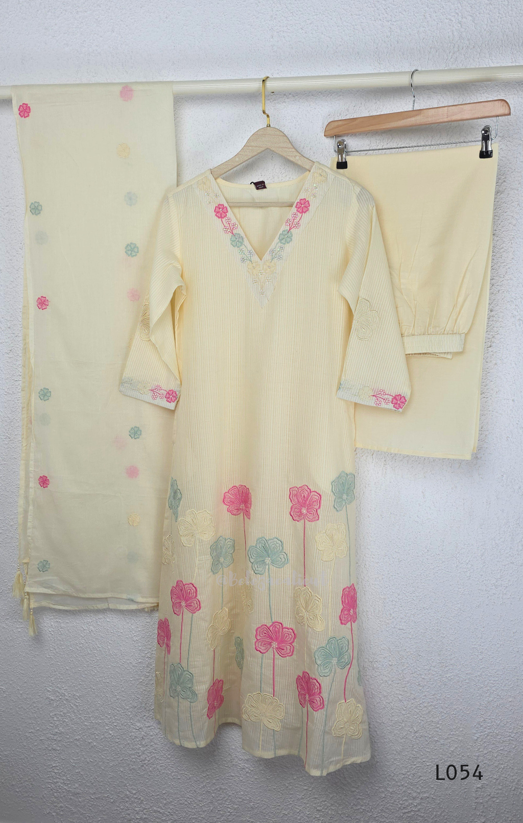 Cream mul cotton churidar set with lining, pastel pink and powder blue floral embroidery, matching dupatta, 3/4 sleeves and V-neck bead detail 