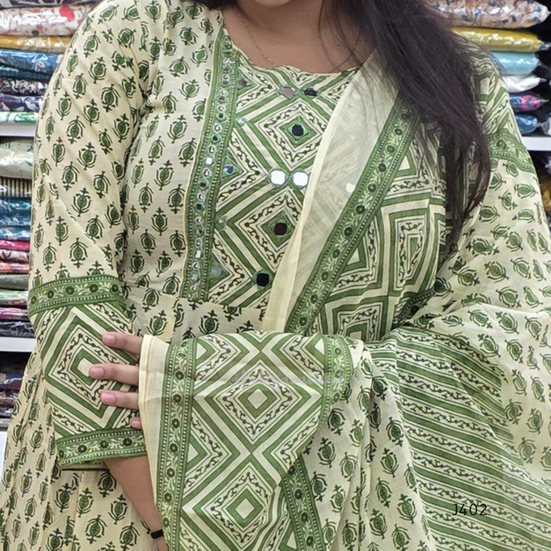 Green and white patterned kurta with matching dupatta held by a person in a fabric store.