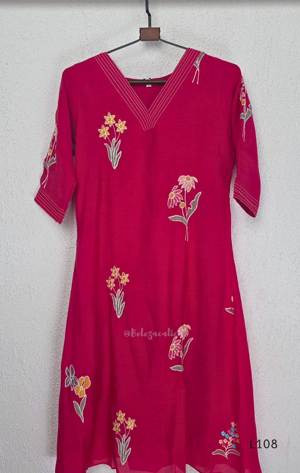 Deep magenta mul chanderi A-line kurti with colourful floral embroidery, V-neck stitch detail and 3/4 sleeves