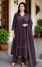 Deep plum cotton churidar suit set with matching bottom and dupatta, mirror detail V-neckline, gold line work on yoke, and elegant festive casual styling.