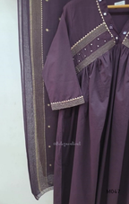 Deep plum cotton churidar suit set with matching bottom and dupatta, mirror detail V-neckline, gold line work on yoke, and elegant festive casual styling.