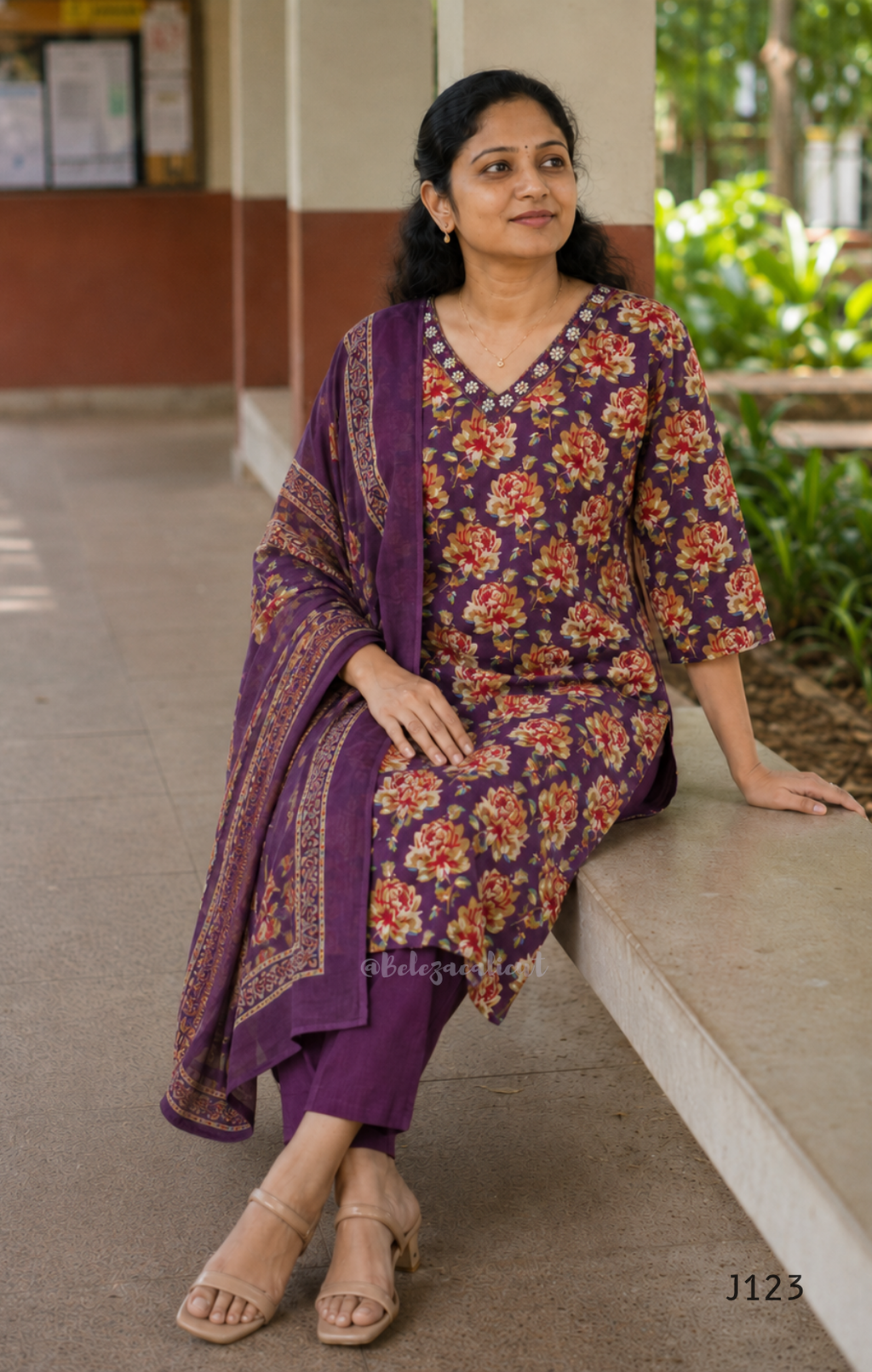 Deep purple cotton churidar set with rose floral print, matching dupatta, 3/4 sleeves, and embellished V-neckline displayed on mannequin.