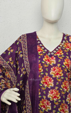 Deep purple cotton churidar set with rose floral print, matching dupatta, 3/4 sleeves, and embellished V-neckline displayed on mannequin.