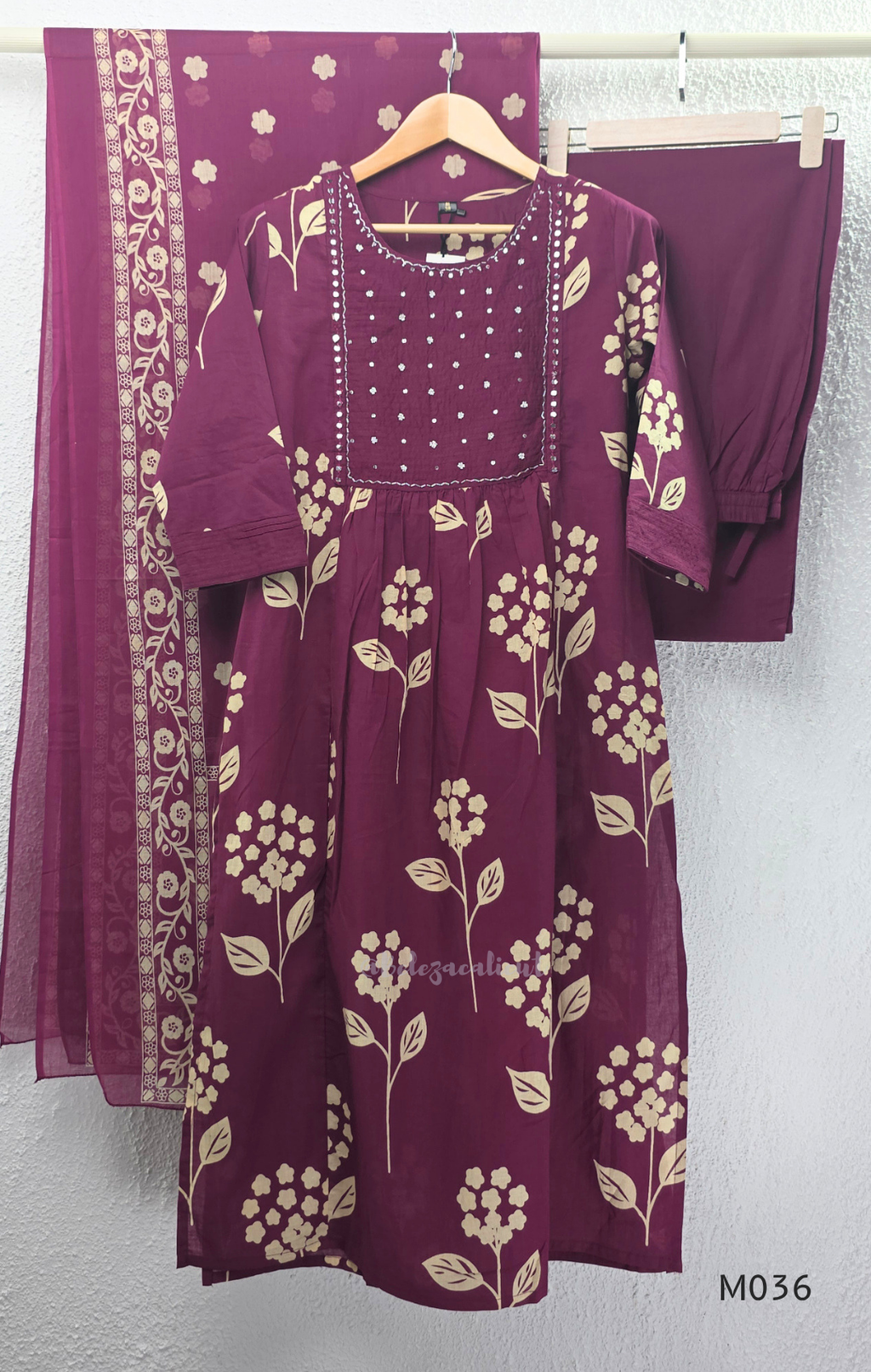Grape cotton churidar set with cream floral stem print, stitched mirror-style yoke work, matching printed dupatta, plain bottom, and 3/4 sleeves.