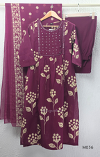 Grape cotton churidar set with cream floral stem print, stitched mirror-style yoke work, matching printed dupatta, plain bottom, and 3/4 sleeves.