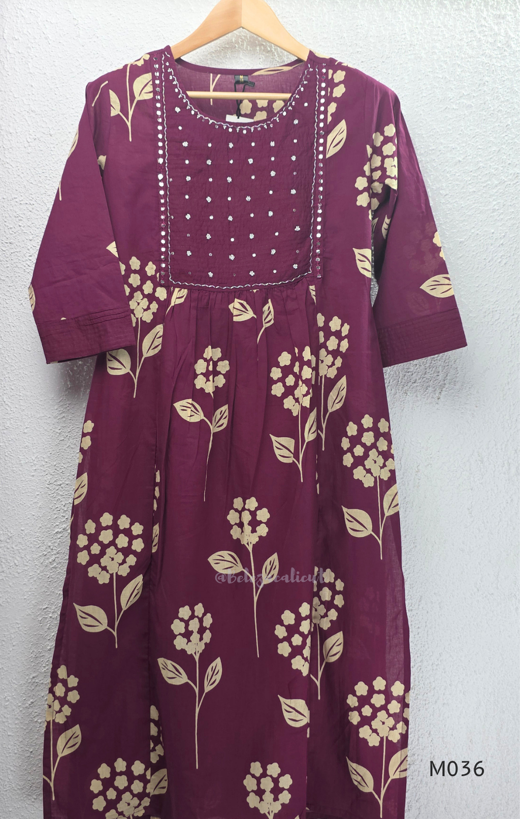 Grape cotton churidar set with cream floral stem print, stitched mirror-style yoke work, matching printed dupatta, plain bottom, and 3/4 sleeves.