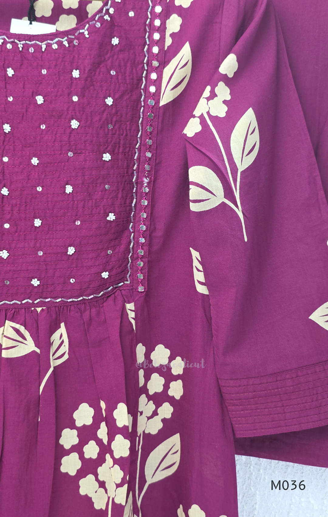 Grape cotton churidar set with cream floral stem print, stitched mirror-style yoke work, matching printed dupatta, plain bottom, and 3/4 sleeves.