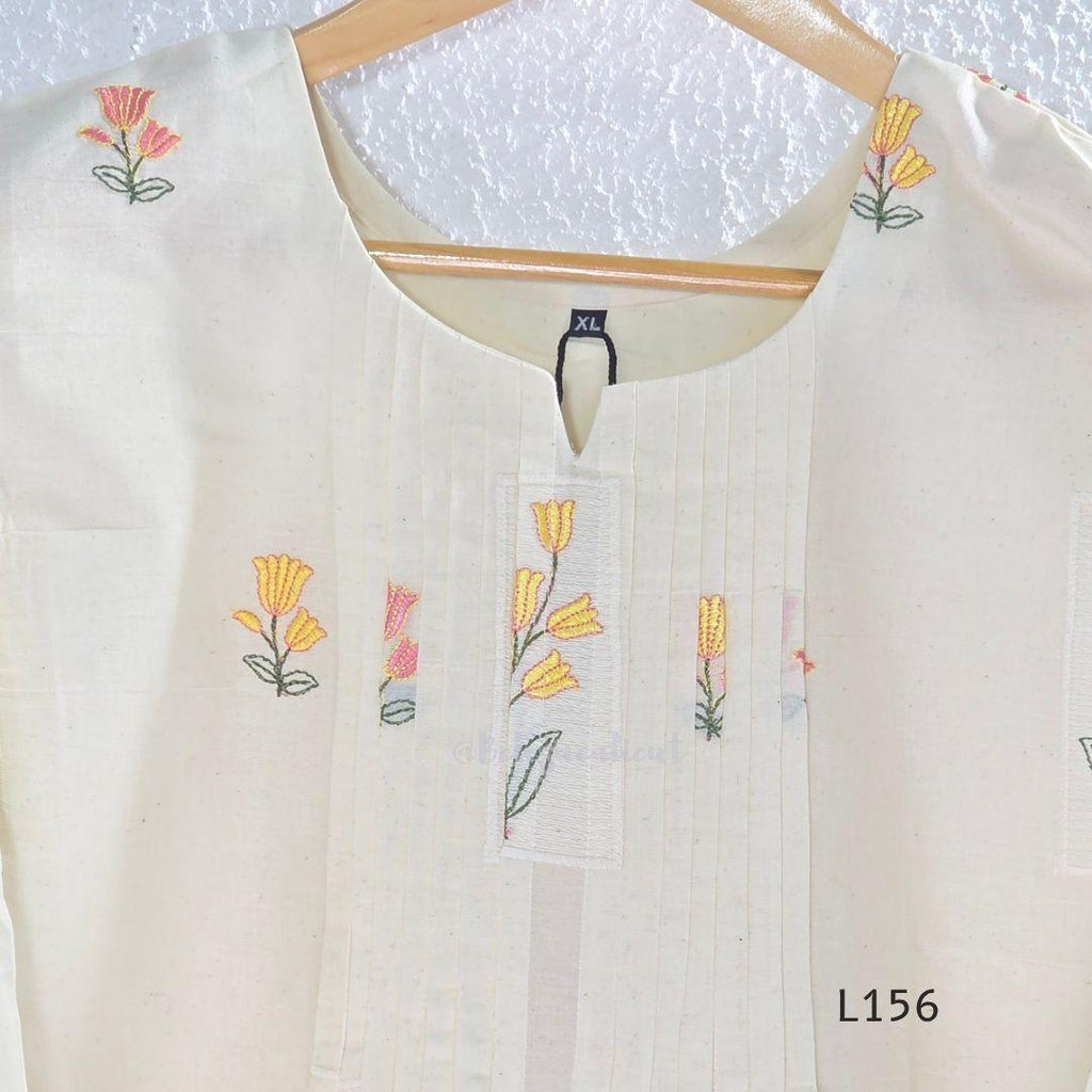 Ivory Cora Cotton churidar set with pink and yellow floral embroidery, matching straight pants and embroidered dupatta.