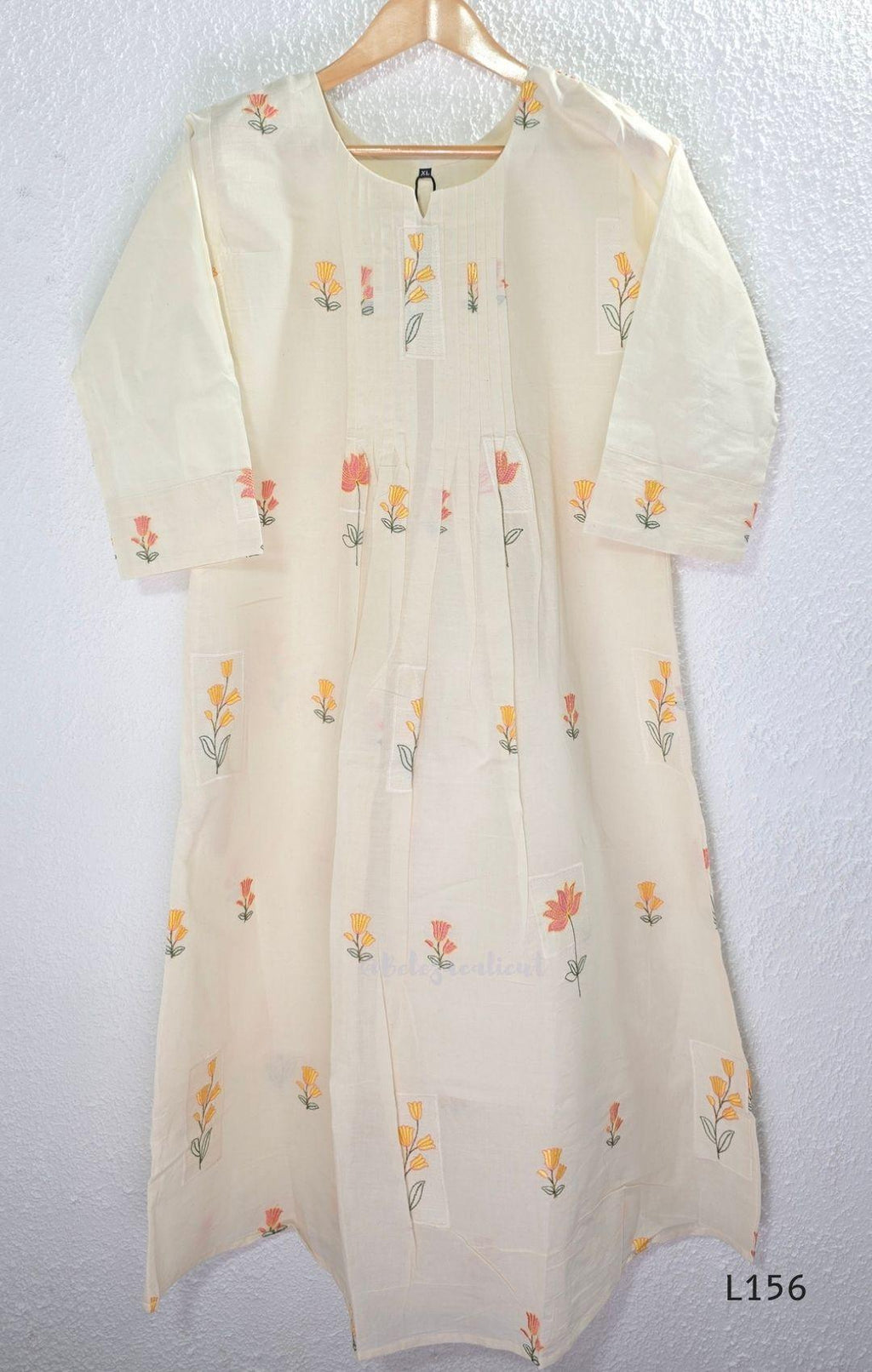 Ivory Cora Cotton churidar set with pink and yellow floral embroidery, matching straight pants and embroidered dupatta.