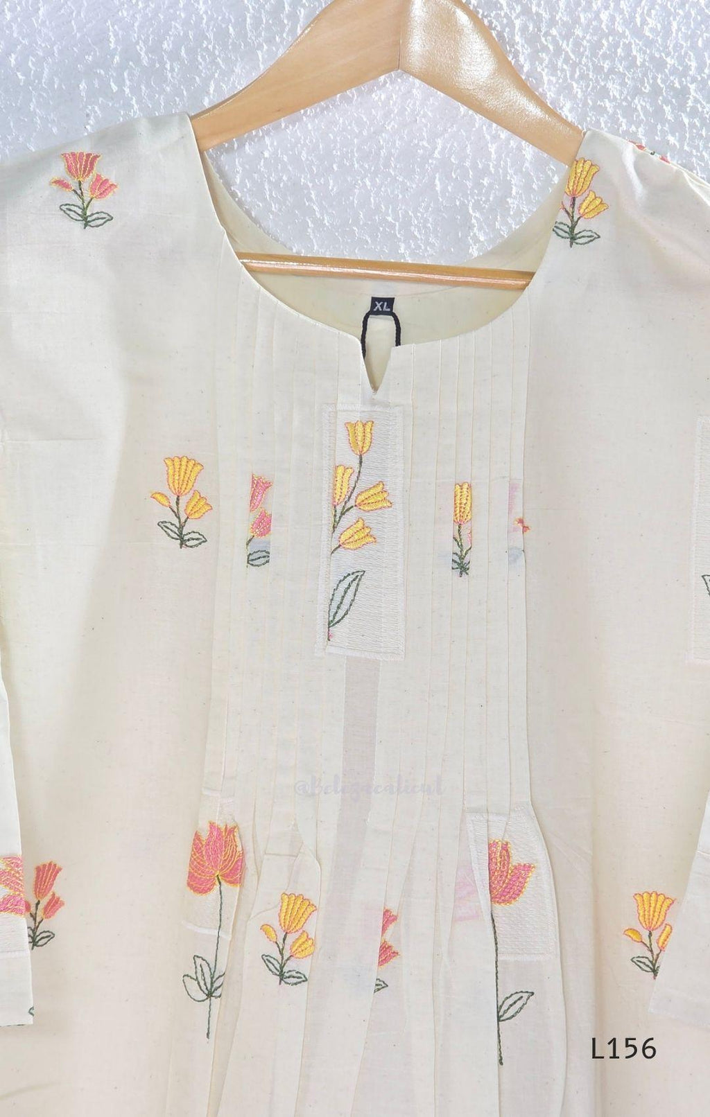 Ivory Cora Cotton churidar set with pink and yellow floral embroidery, matching straight pants and embroidered dupatta.