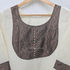 Ivory cotton women’s ethnic top with brown printed yoke, small button detail, printed sleeve cuffs, and straight fit.