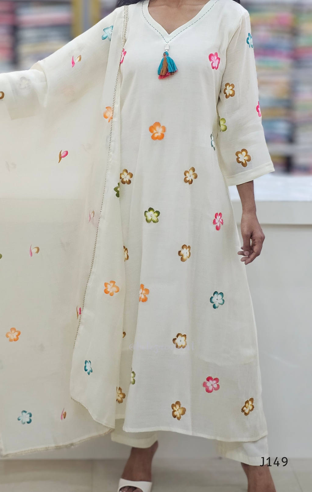 White kurta with colorful floral embroidery on a blurred background