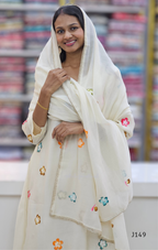 Woman wearing a white traditional outfit with floral embroidery in a store setting