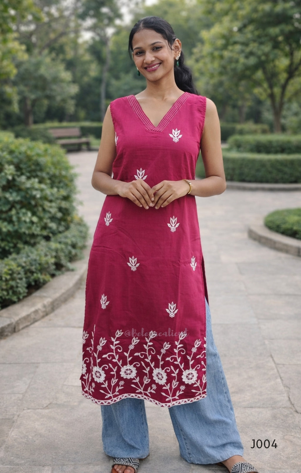 Woman wearing a pink embroidered kurta with blue pants in an outdoor setting