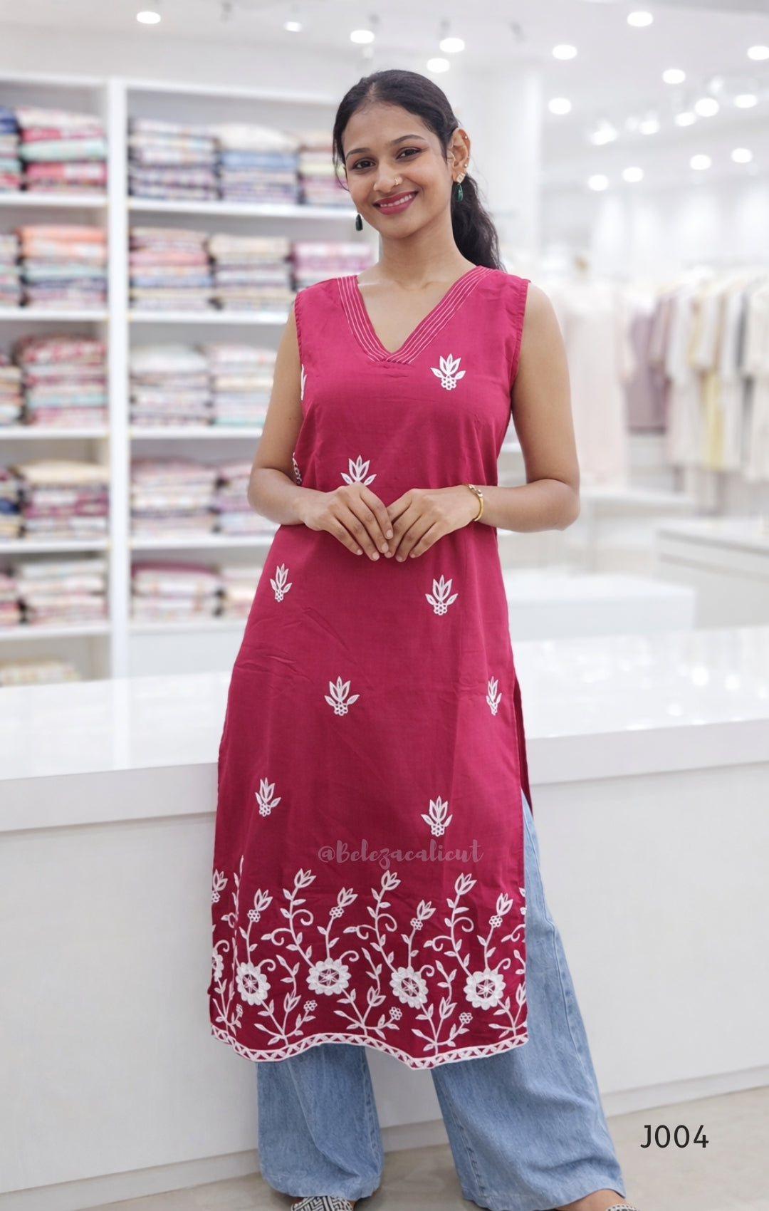 Woman wearing a pink embroidered dress in a fabric store