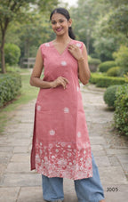 Woman wearing a pink kurta with white floral patterns in a garden setting