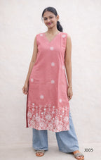 Woman wearing a pink sleeveless kurta with white floral patterns on a plain background
