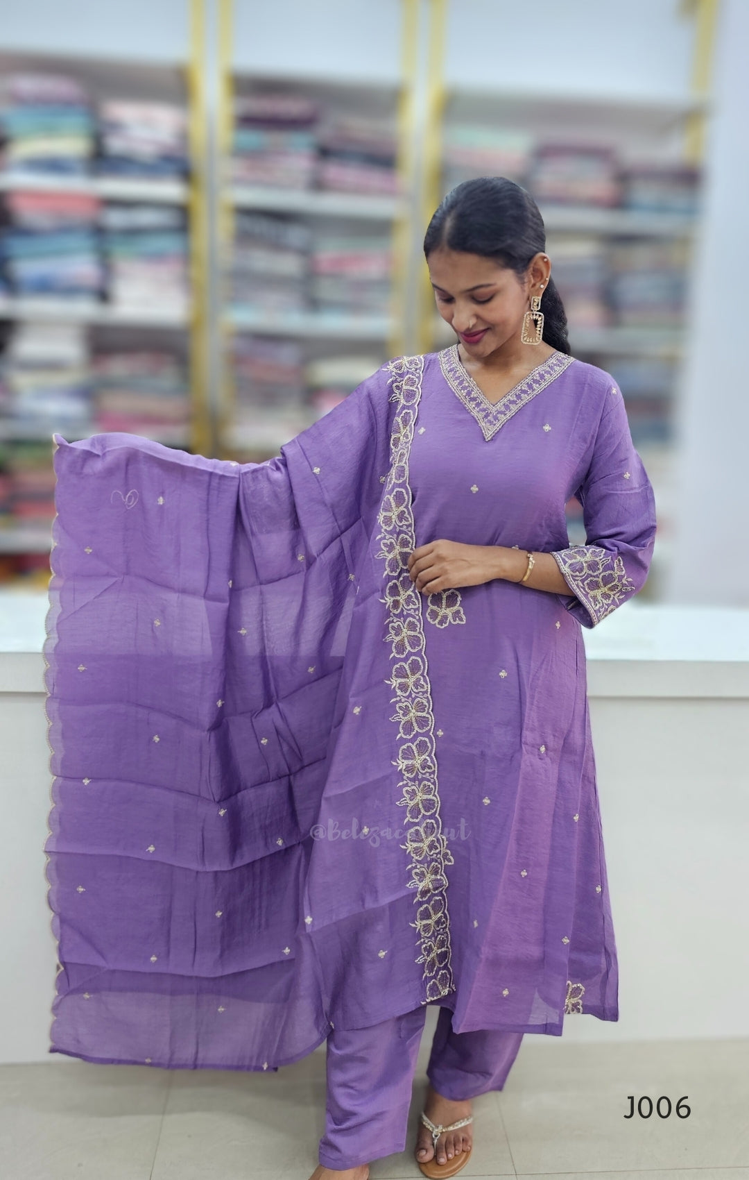 Woman wearing a purple traditional outfit with a matching dupatta in a bookstore setting
