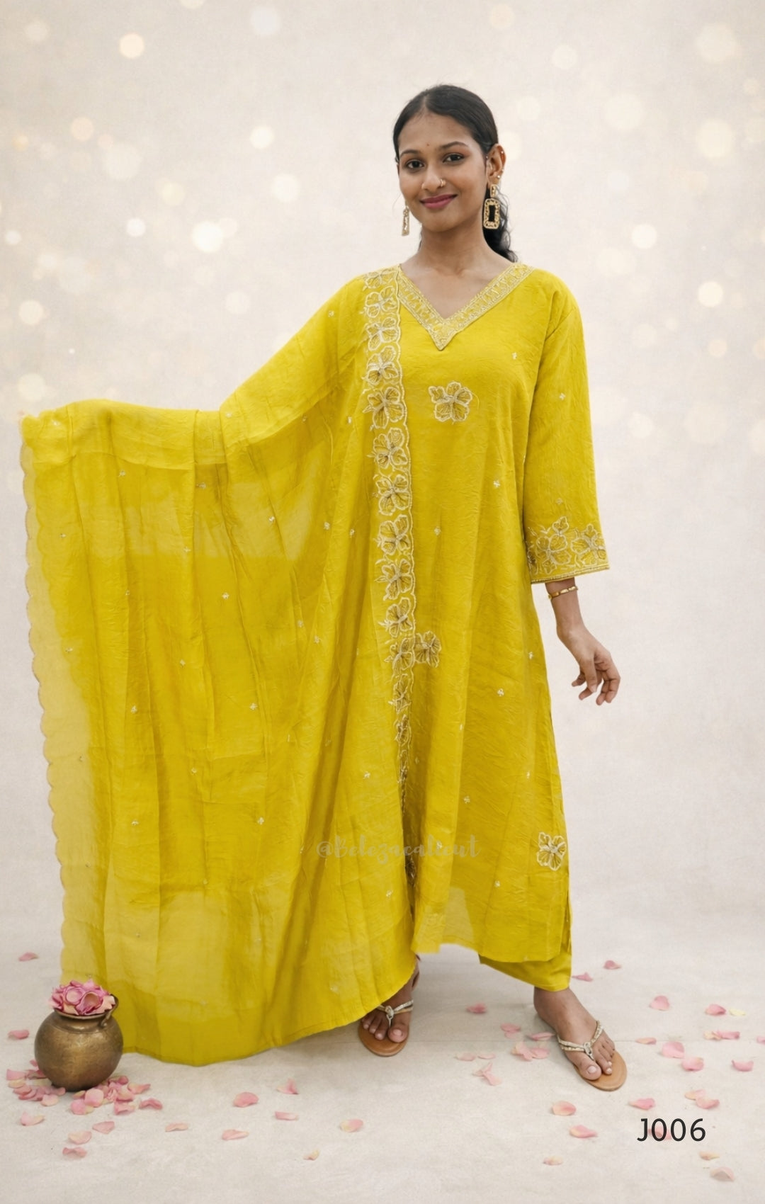 Woman wearing a yellow traditional outfit with a matching dupatta on a white background