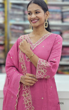 Woman wearing a pink embroidered traditional outfit with a blurred background