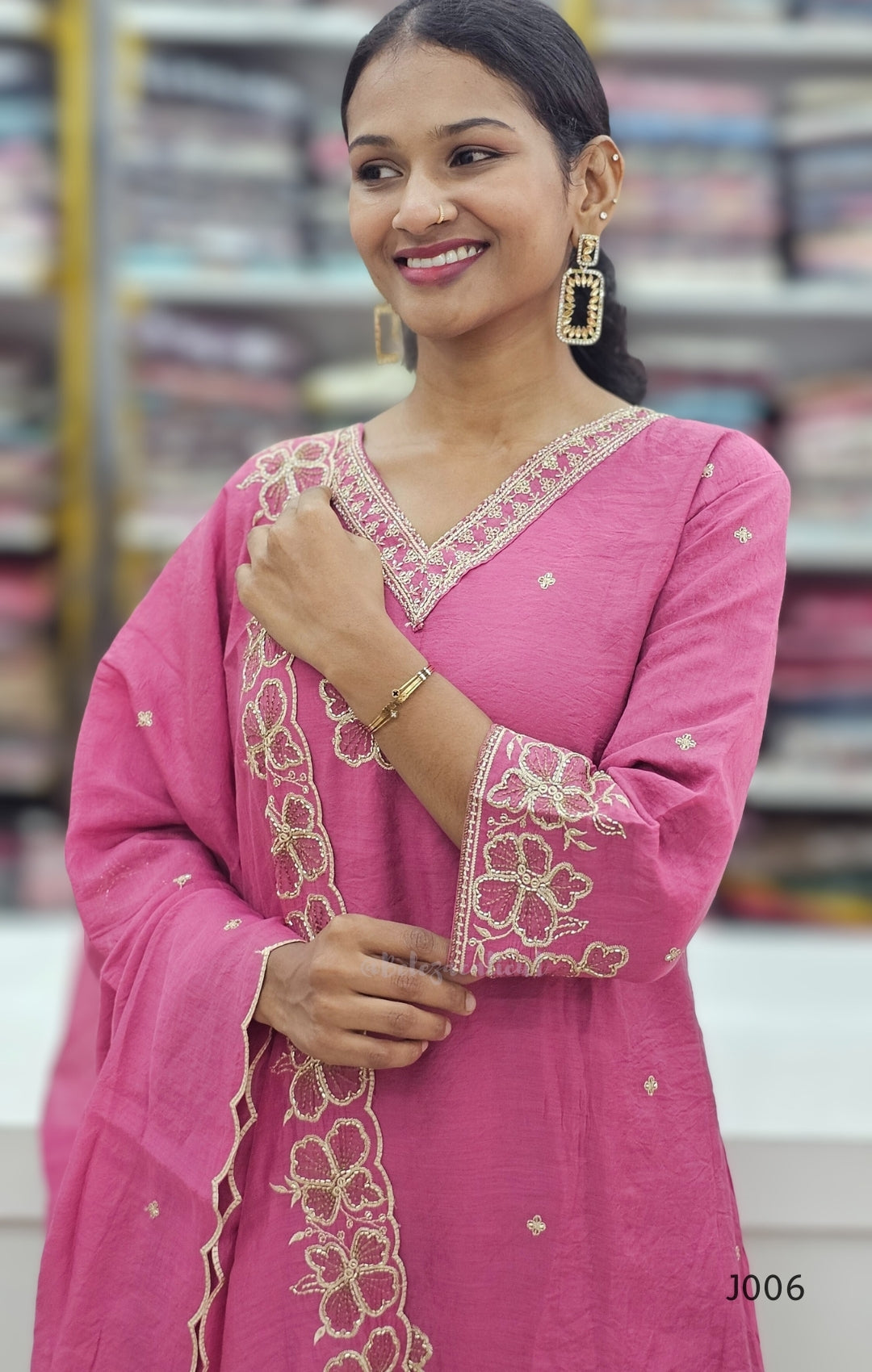 Woman wearing a pink embroidered traditional outfit with a blurred background