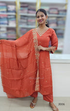 Woman wearing an orange traditional outfit with a dupatta in a store setting