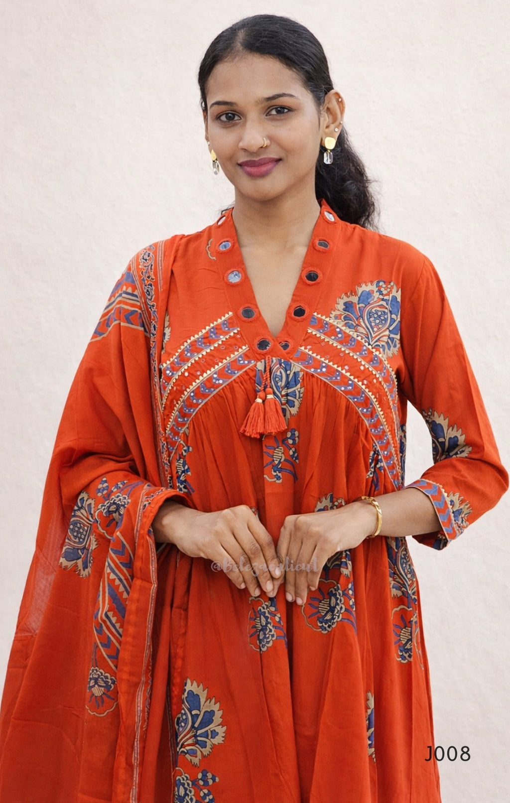 Woman wearing a red embroidered traditional outfit on a white background