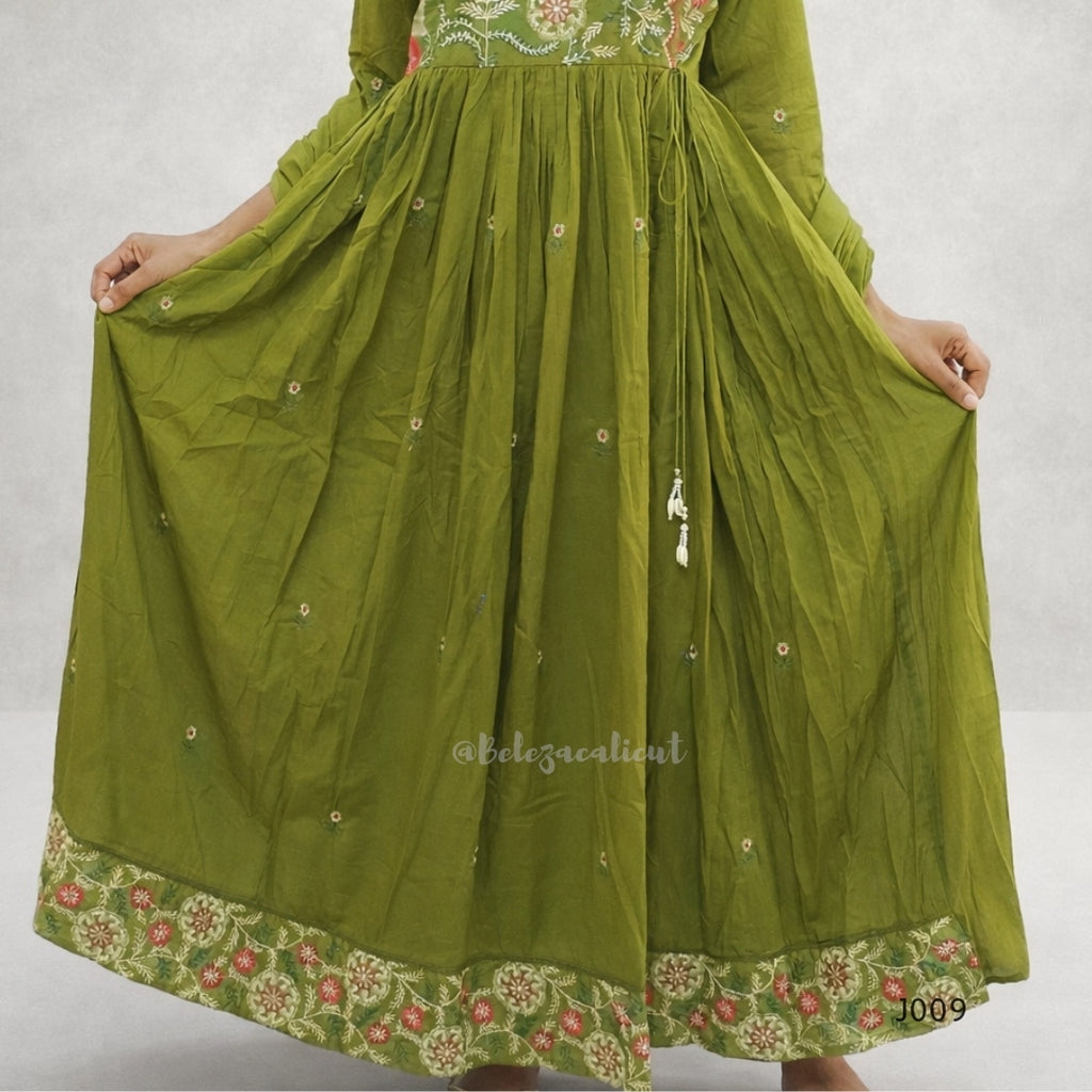 Green embroidered dress with a sheer overlay on a white background