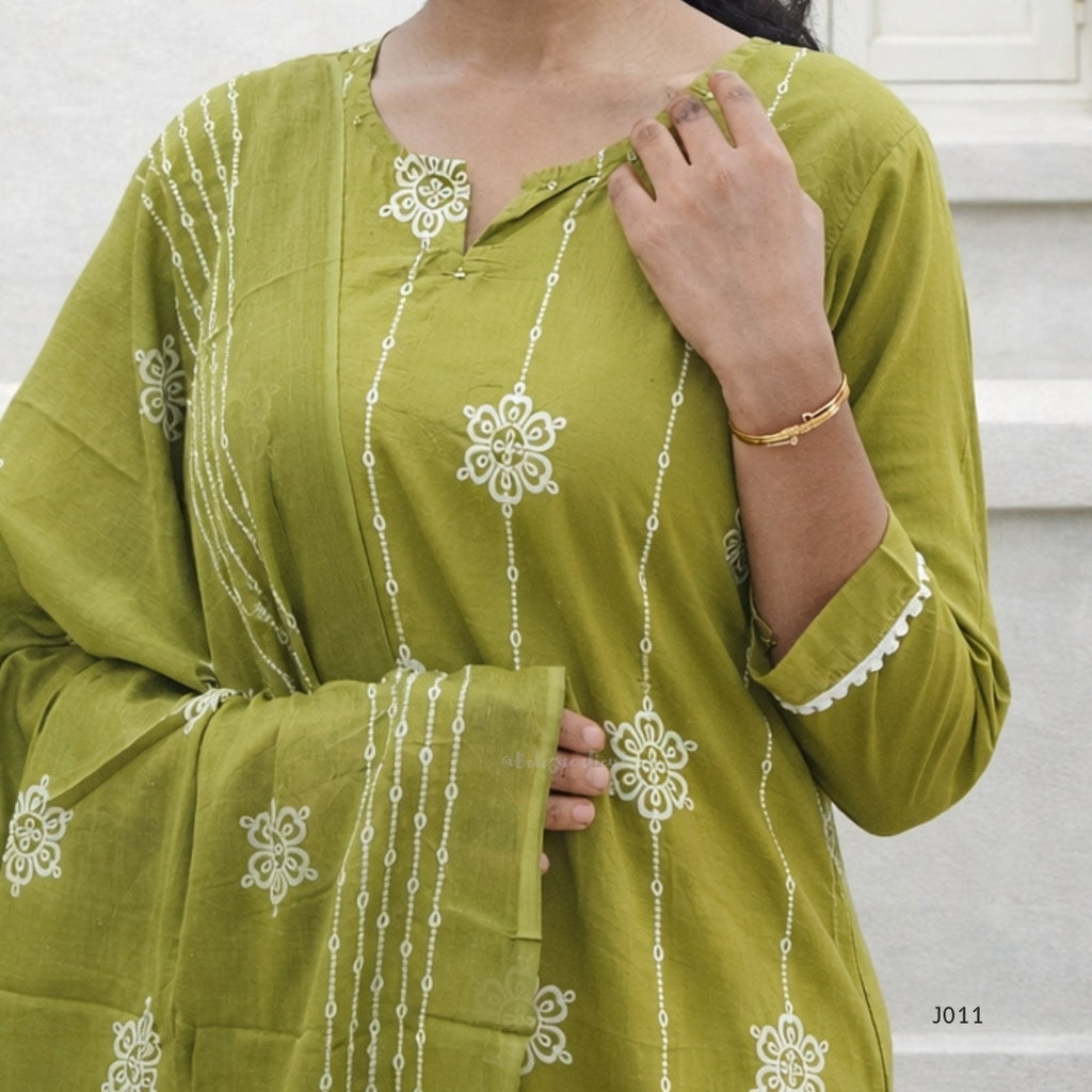 Green embroidered traditional outfit with white patterns on a neutral background
