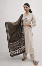 Woman holding a patterned scarf against a white background