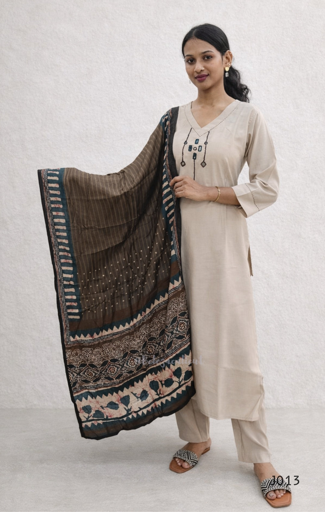 Woman holding a patterned scarf against a white background