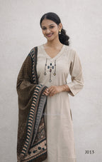 Woman wearing a beige kurta with a brown and black patterned dupatta on a light gray background