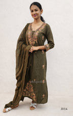 Woman wearing a green traditional outfit with embroidery on a white background