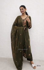 Woman wearing a green traditional outfit with intricate designs on a white background