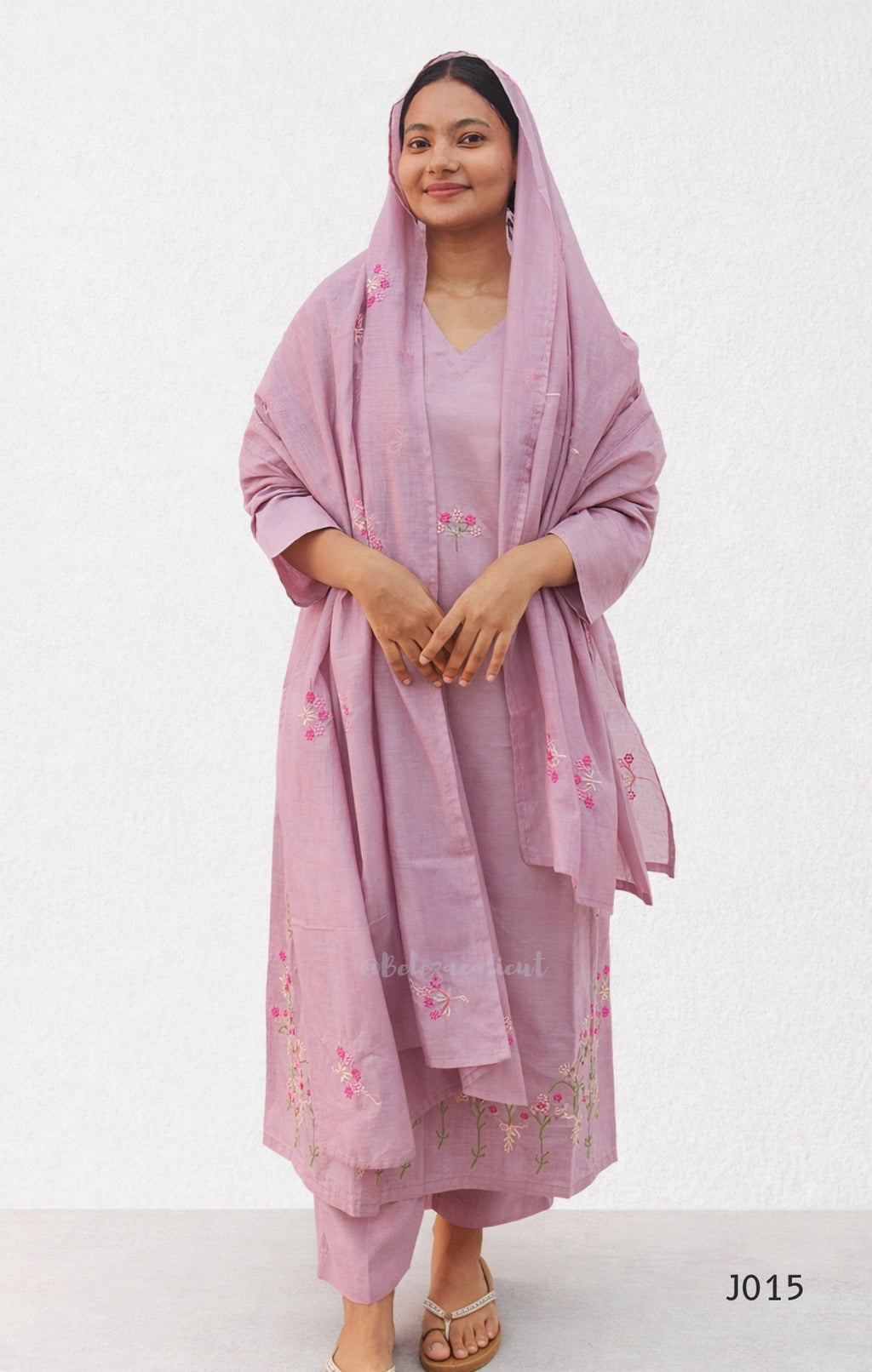 Woman wearing a pink traditional outfit with a matching dupatta on a white background
