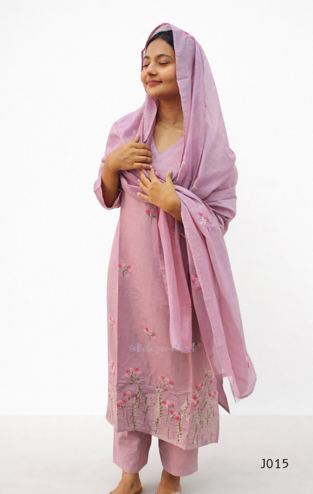Woman wearing a pink traditional outfit with a matching dupatta on a white background