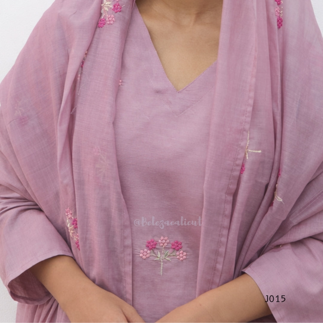 Pink traditional outfit with floral embroidery on a plain background