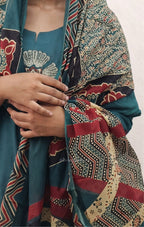 Person wearing a colorful patterned garment with a plain background