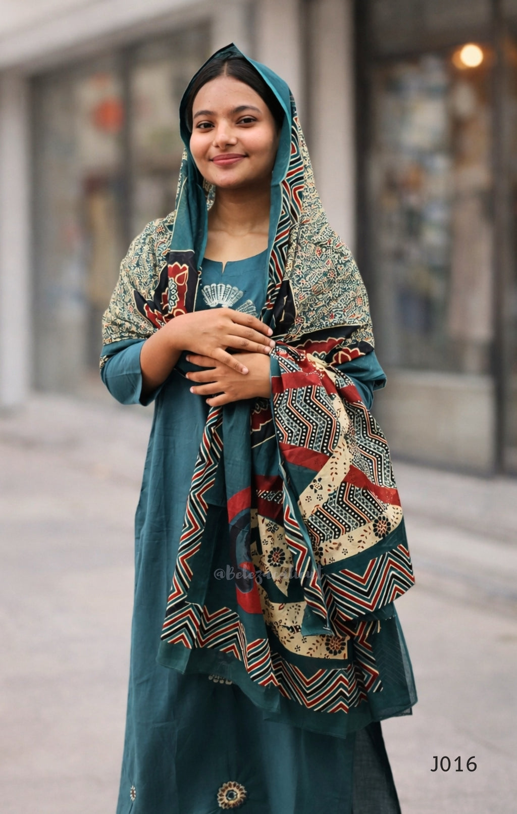 Woman wearing a traditional outfit with a colorful shawl in an urban setting