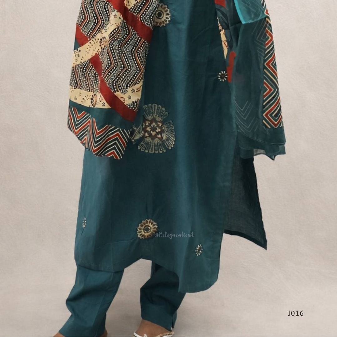 Teal traditional outfit with intricate patterns on a beige background