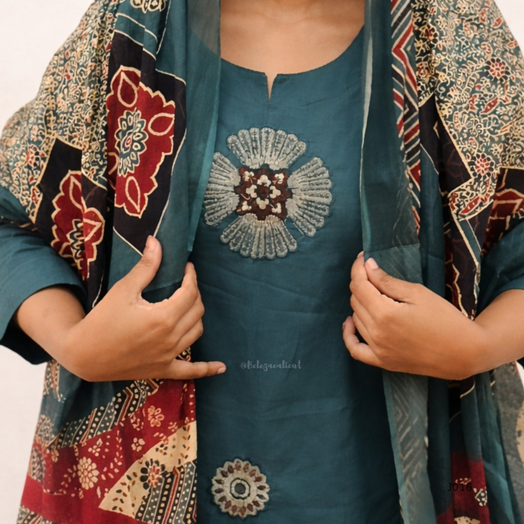 Teal outfit with floral embroidery and a patterned shawl