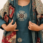 Teal outfit with floral embroidery and a patterned shawl