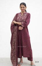 Woman wearing a maroon traditional outfit with a matching dupatta on a white background