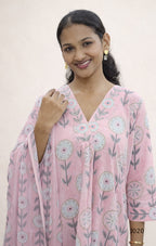 Woman wearing a pink floral dress against a plain background