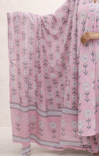 Pink floral patterned fabric draped over a person on a light background