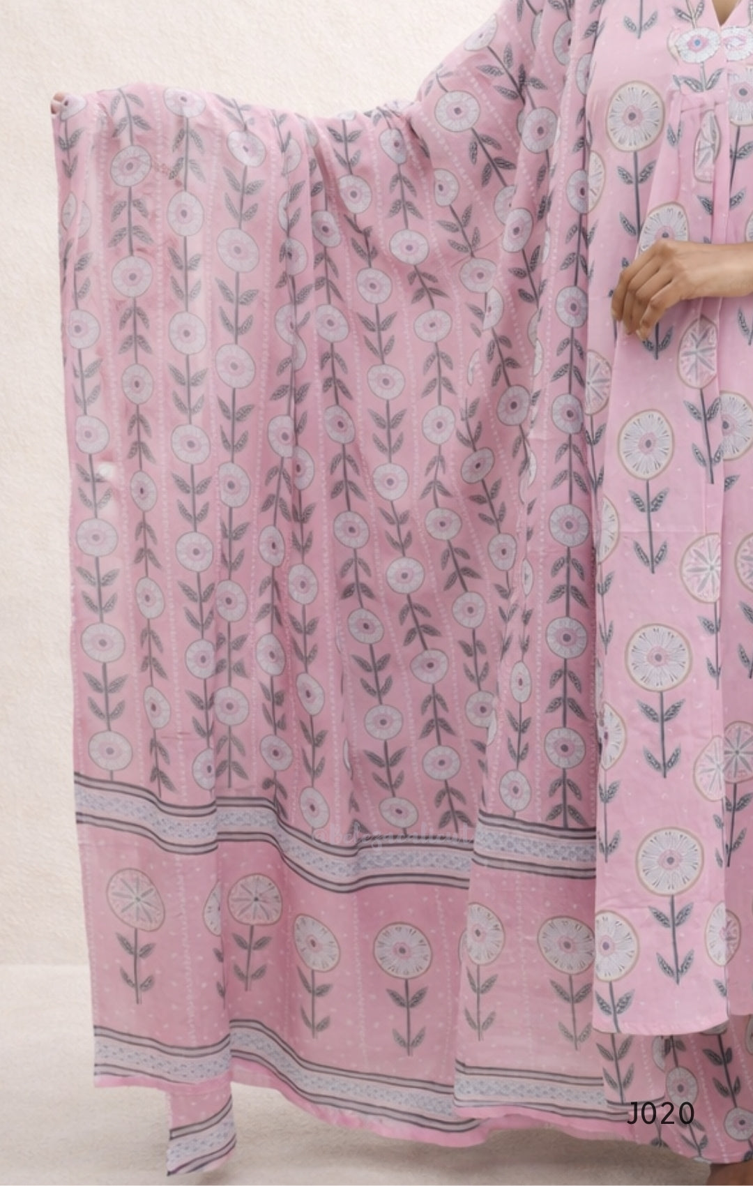 Pink floral patterned fabric draped over a person on a light background