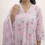 Person wearing a pink floral dress with a plain background