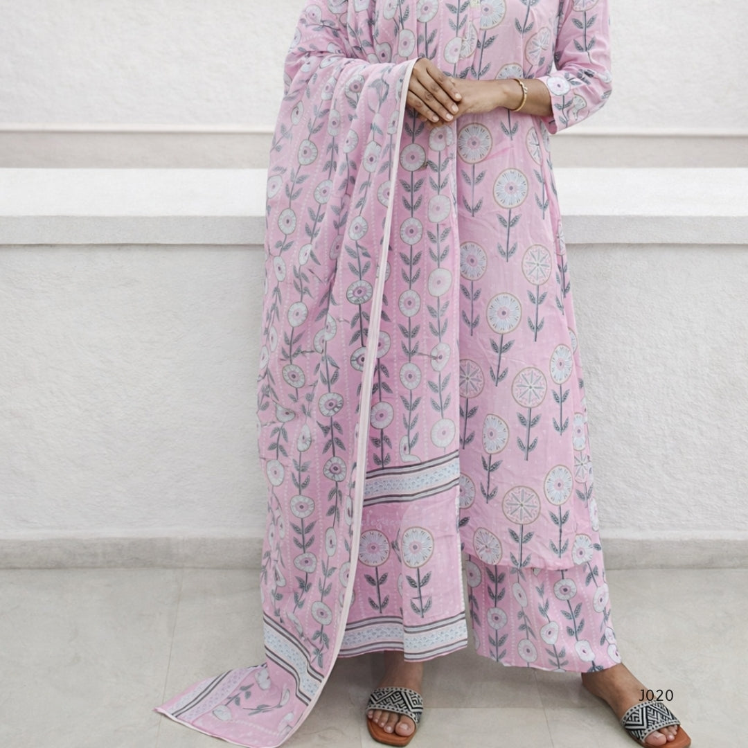 Person wearing a pink floral outfit with a matching dupatta on a white background