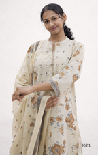 Woman wearing a cream-colored saree with floral patterns on a white background